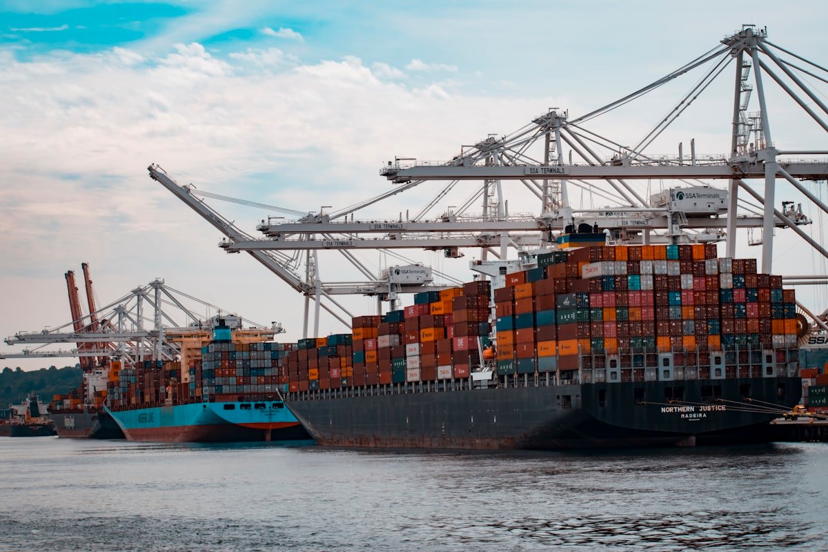 Buque portacontenedores en puerto siendo cargado por grúas